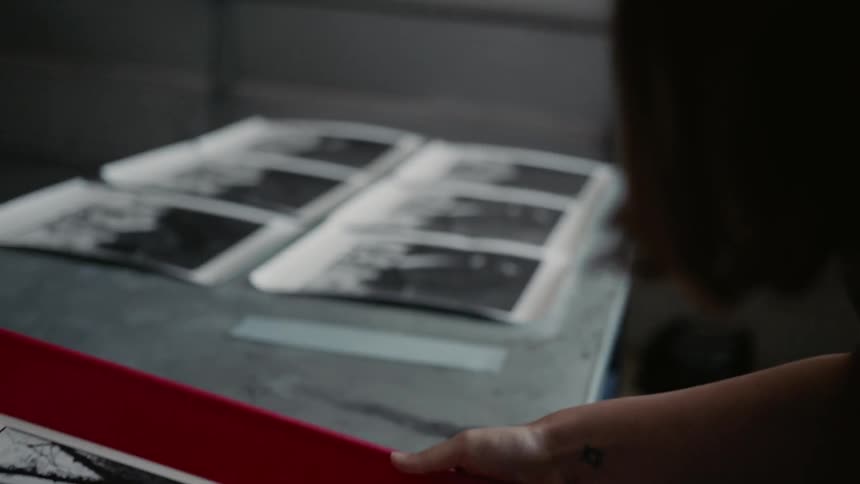 A woman looks at a photograph in a tray