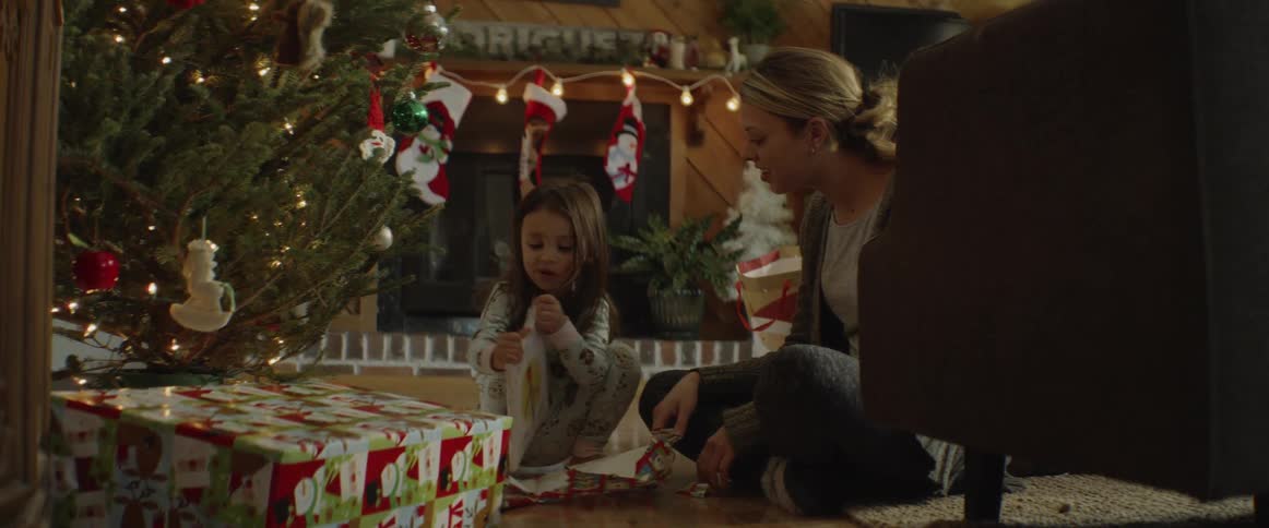 A girl opens a present on christmas morning