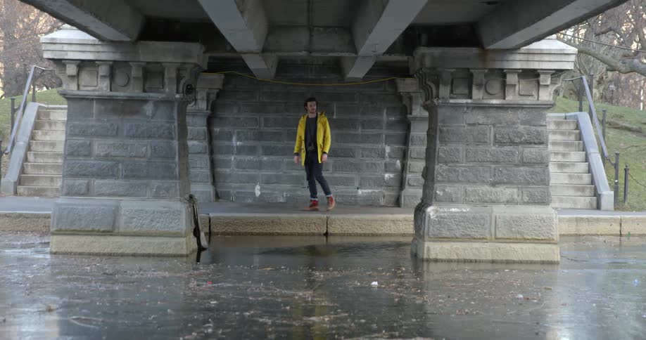 A man walks under a bridge