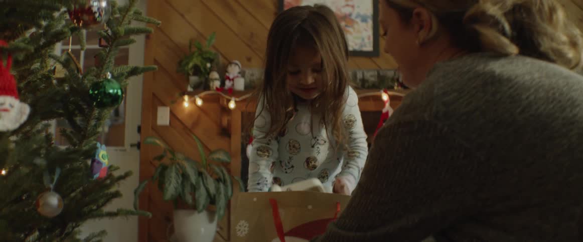 A girl lifts a present out of a gift bag at christmas
