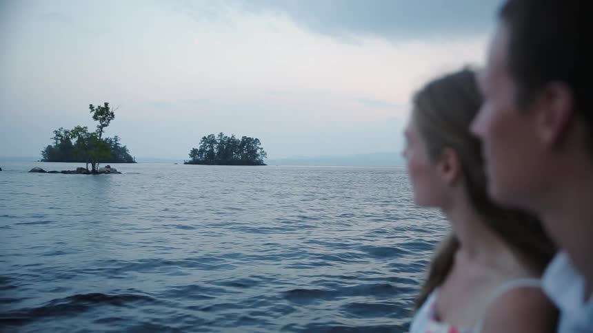 A man and woman sit in a watercraft looking at the large open water scenery
