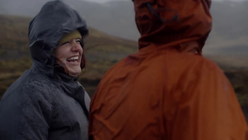 People laugh as they are buffeted by the wind