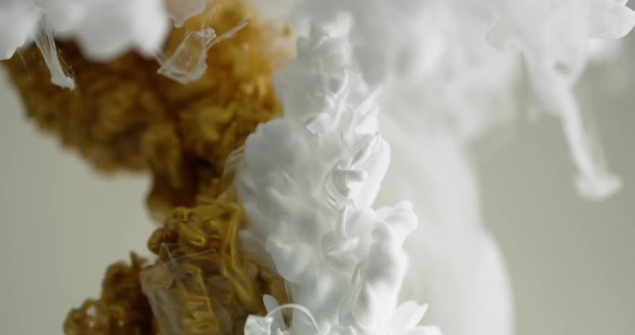White liquid pours down into water
