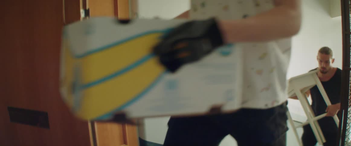 Close up view of a person carrying a heavy cardboard box up stairs.