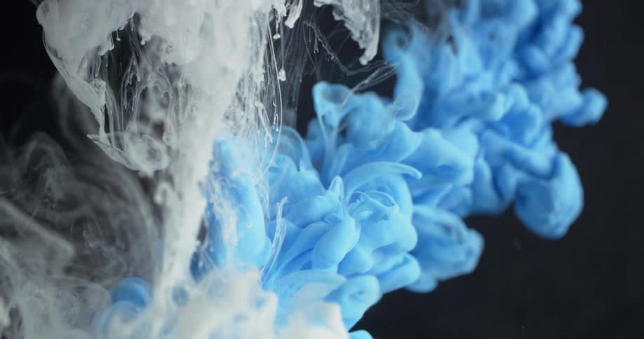 White and blue dyes are pouring into and spreading out in a liquid solution