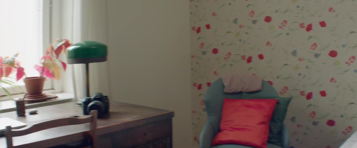Blond woman sleeping in her bedroom that has floral wallpaper