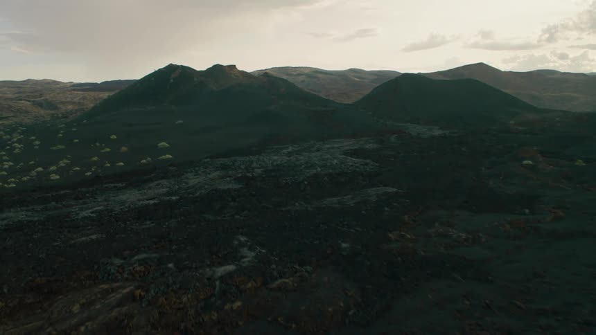 A rocky landscape is dotted with areas of green