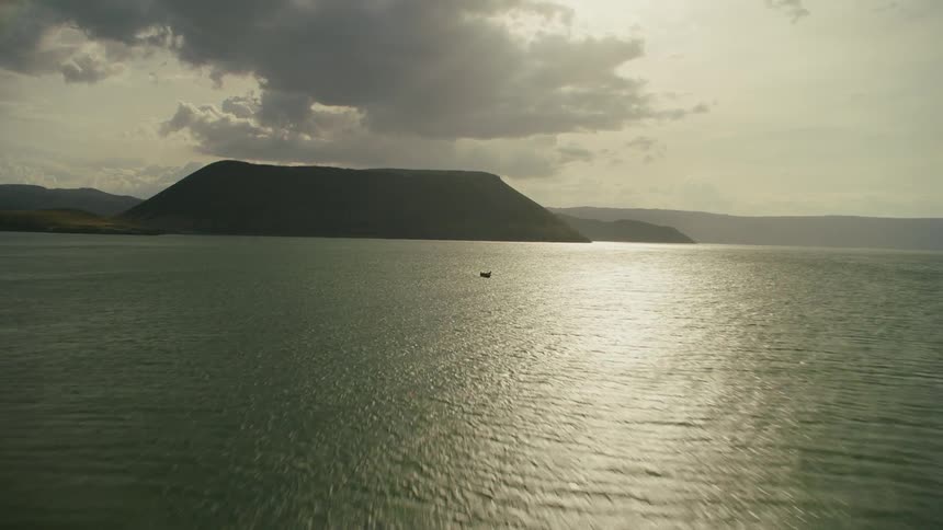 Boat floats on the open water on a cloudy day