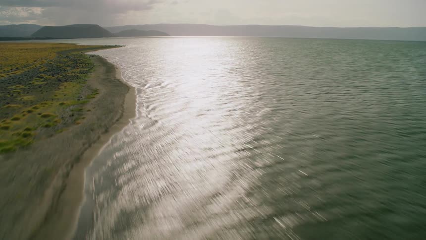 The sun shine reflects off a large lake