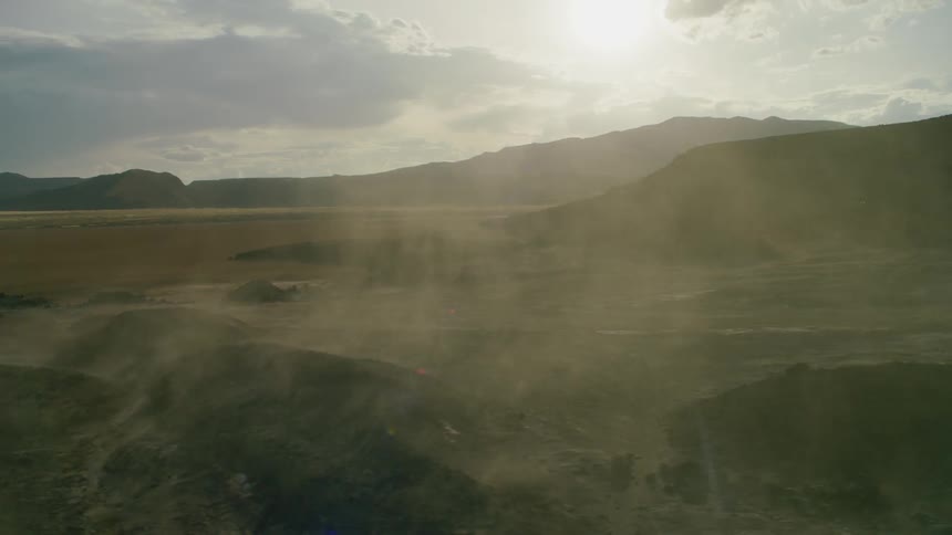Sun shines through clouds over the hills and fog rises from the plains