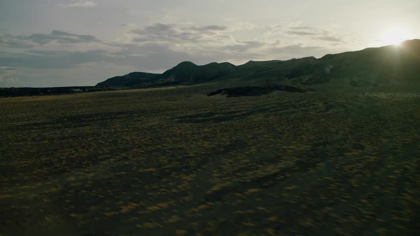 Sunlight is streaming over a hill in a natural setting in daylight