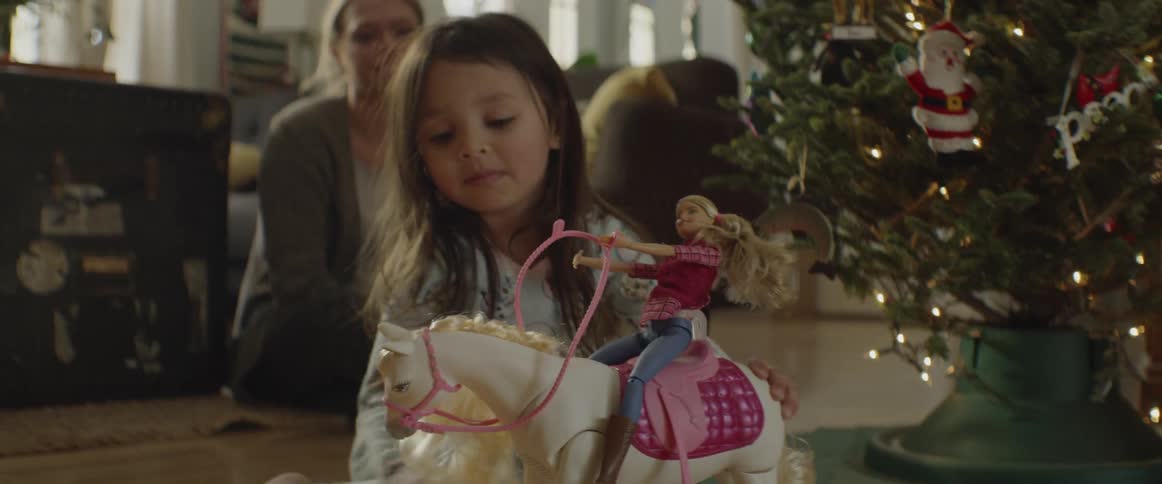 Little girl plays with barbie and toy horse she got for christmas