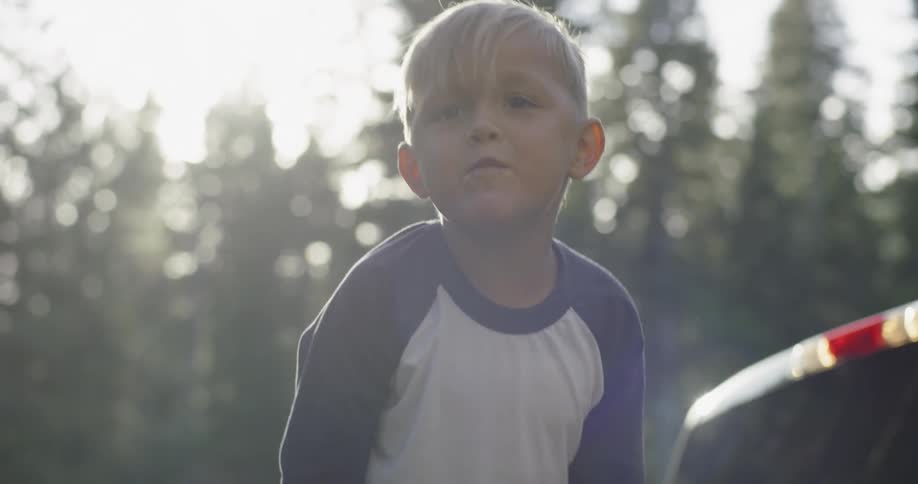 Little boy smiles and talks from the bed of truck