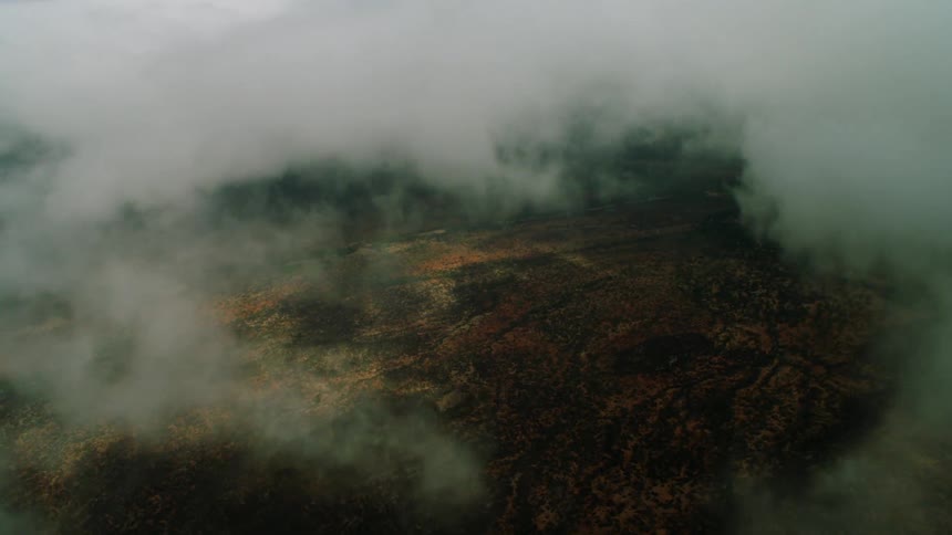 An opening in the clouds shows the landscape below