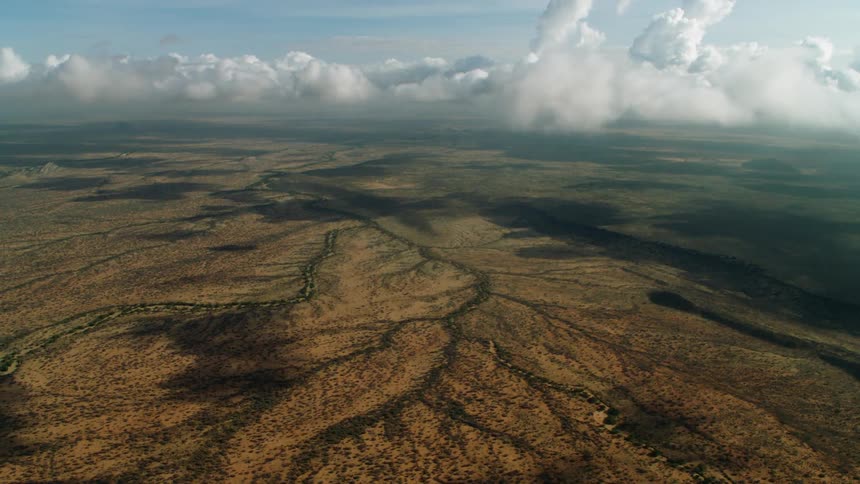 Clouds hover over a dry mountain range