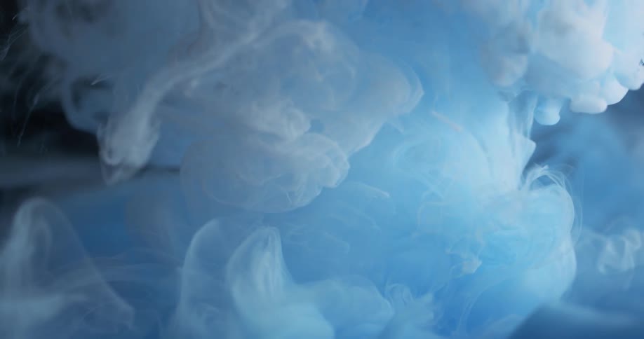 White and blue dyes are pouring into and spreading out in a liquid solution