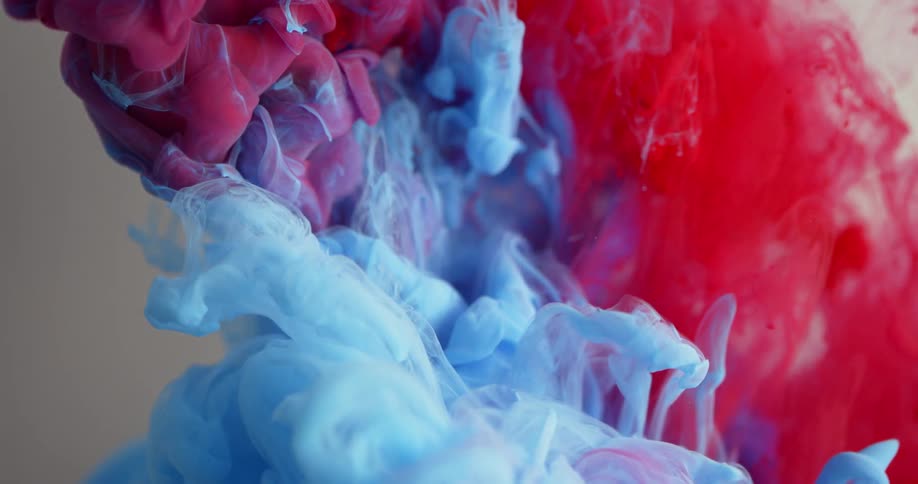 Blue and red liquid mix together in clear liquid