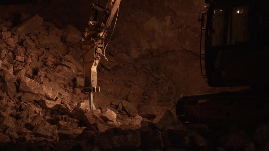 A jackhammer construction tool carves through rock