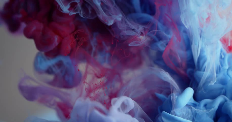 Blue and red liquid mix together in clear liquid
