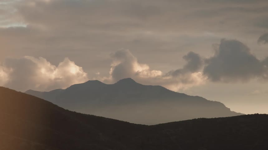 Silhouette of a mountain under clouds