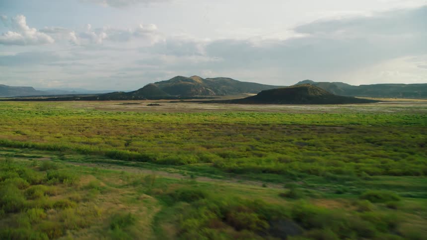 Wide grassy plains with hills nearby