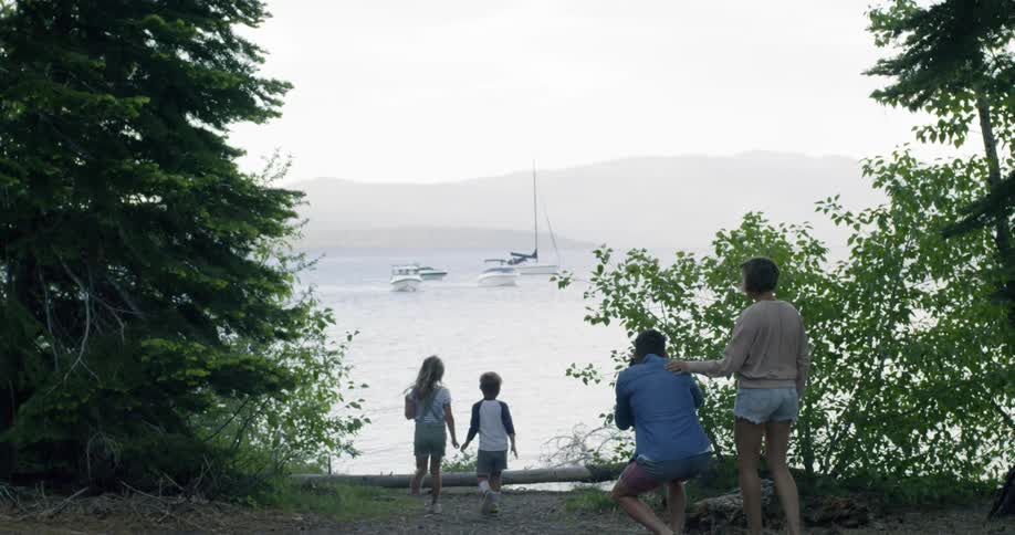 A father is stopping to take photos of his family as they walk toward the coast