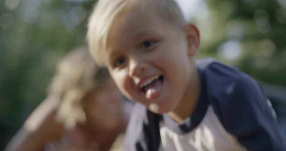 A boy in a truck bed laughs as he reaches for someone