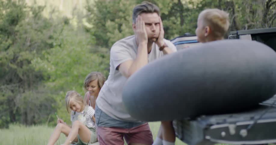 A family are playing and socializing outside in a natural setting in daylight