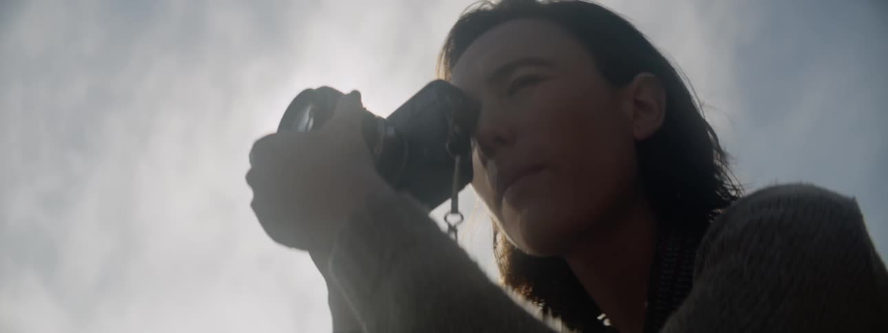 Woman taking photographs under the bright sunlight