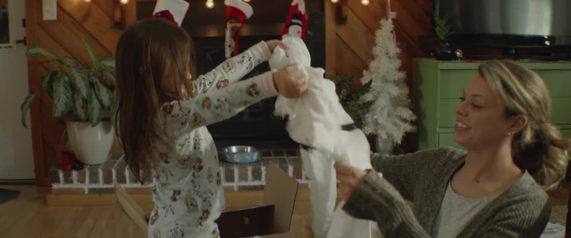 Child unwraps a present on christmas morning