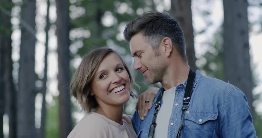 A man and woman embrace outside