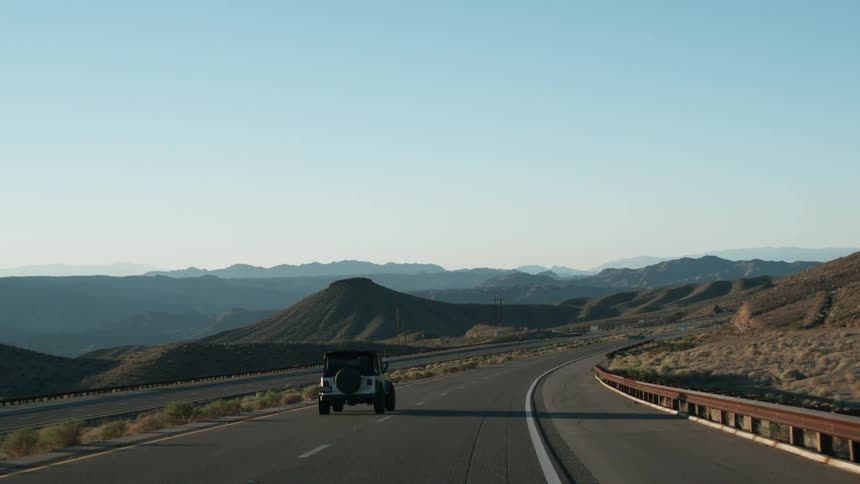 Jeep drives down a country road on a clear day