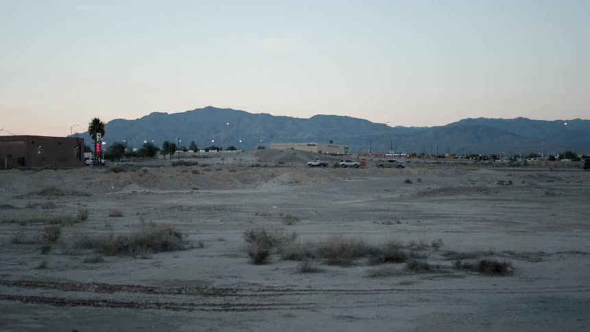 Cars drive along a suburban desert highway