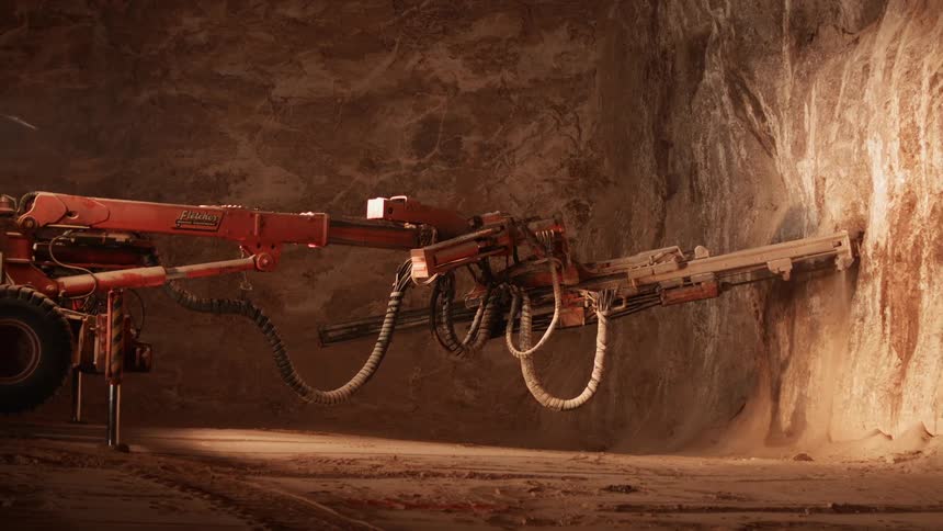 Mining equipment cuts into a rock wall