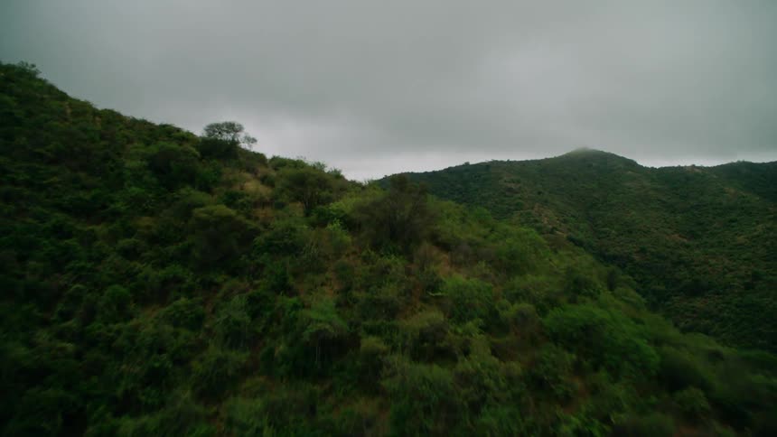 Thick clouds covering the sky over green mountains
