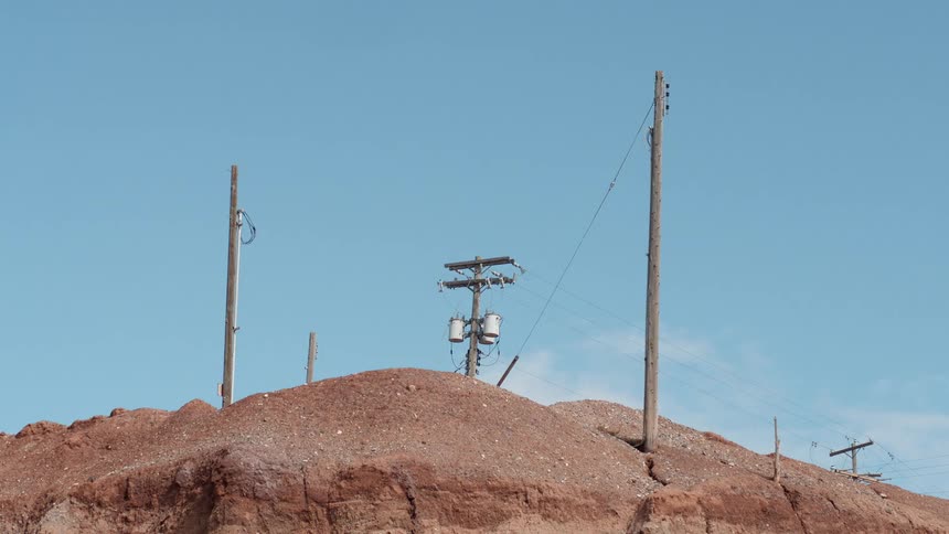Power lines on a hill in the desert