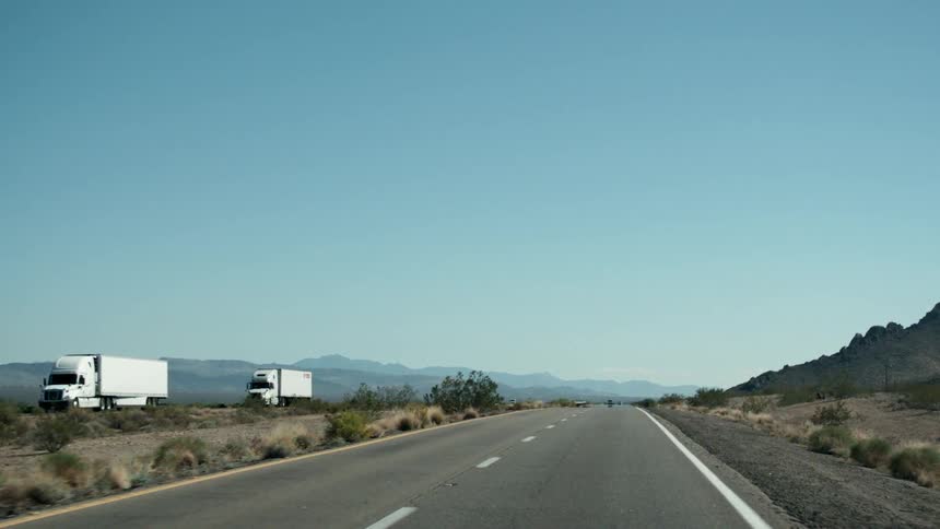 Trucks drive down a highway in the country
