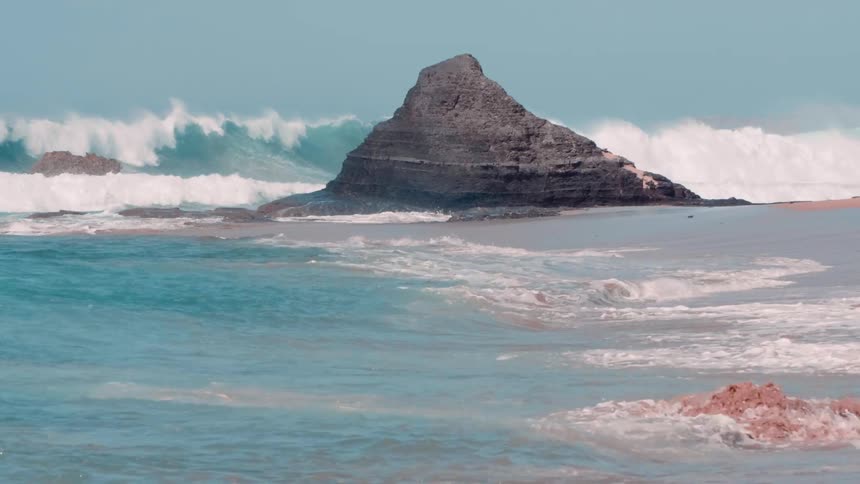 Ocean waves break and splash on the rocks