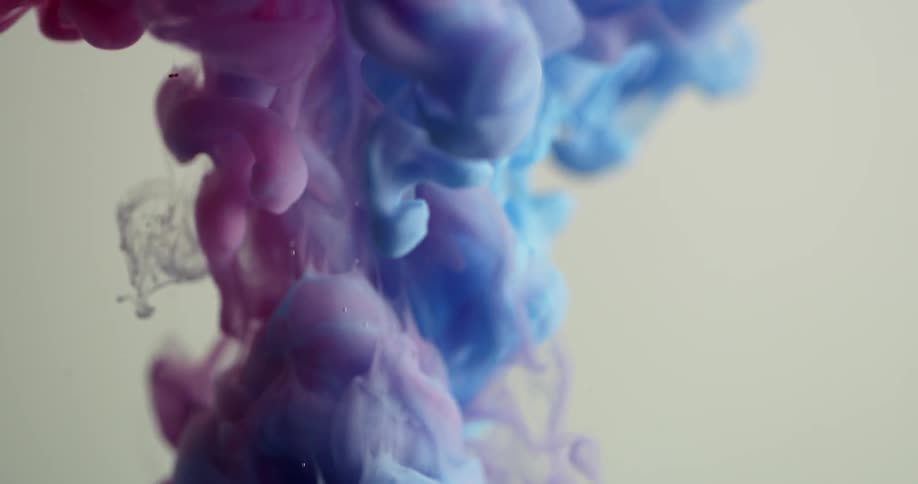 Clouds of colored dye burst into water then sink