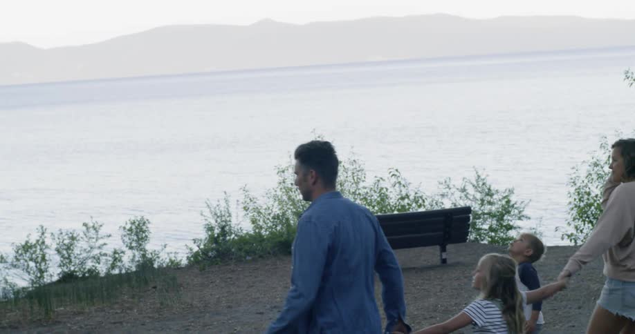 Parents walk with their children over to the lake