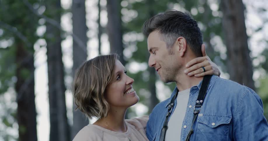 Man and woman smiling and kissing outside in nature