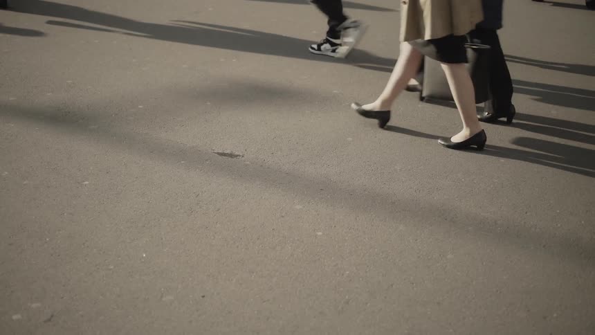 Crowd of people walking on pavement during the day
