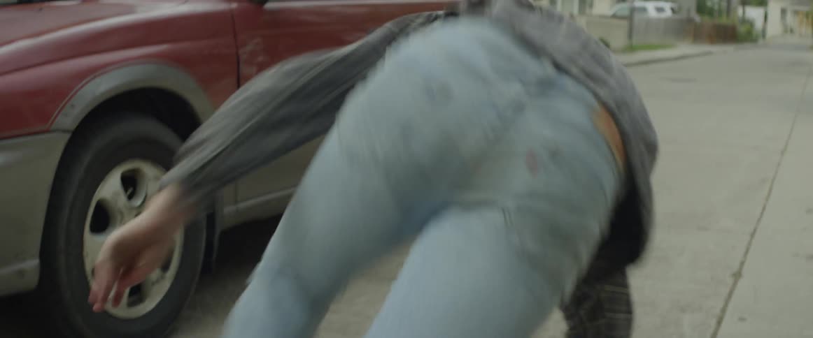 A running man slides over the hood of a car then gets up and runs
