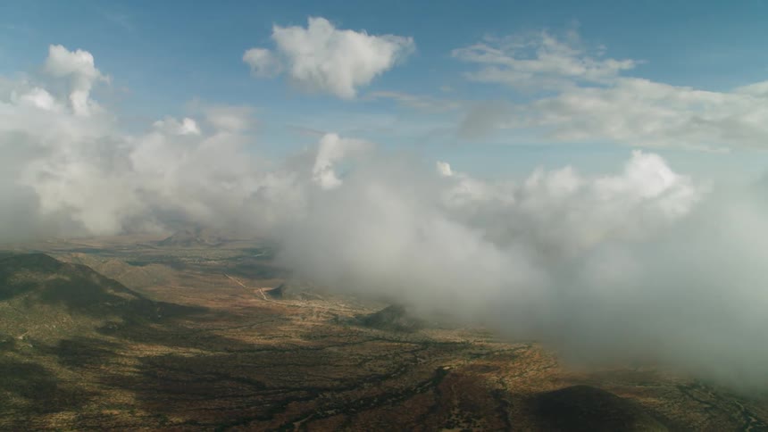 Clouds float over rural mountains