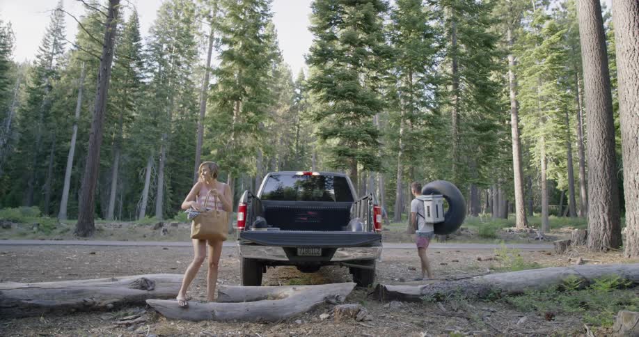 Man and woman unload a truck in the woods