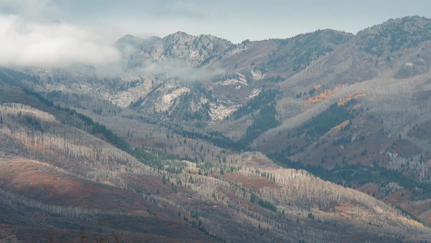 White clouds pass between two mountains