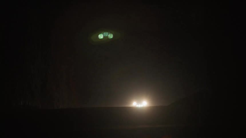 A car with headlights on enters a cave