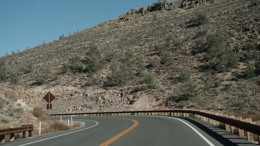 Guardrails line both sides of a mountain road