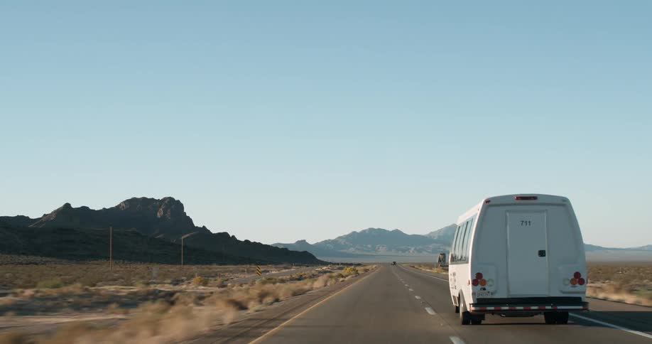 Cars traveling on desolate highway on sunny day