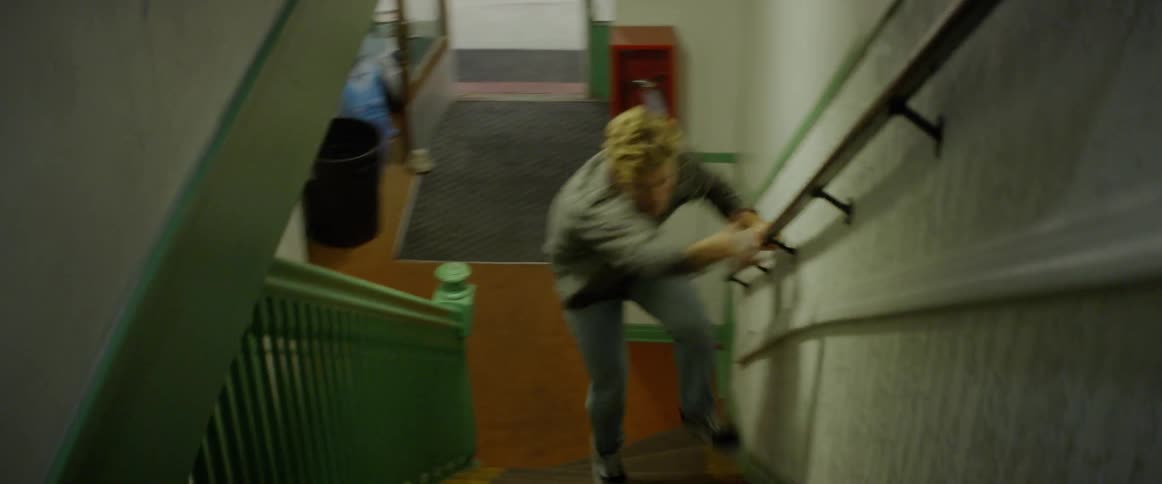 A man enters a building and runs up the stairs